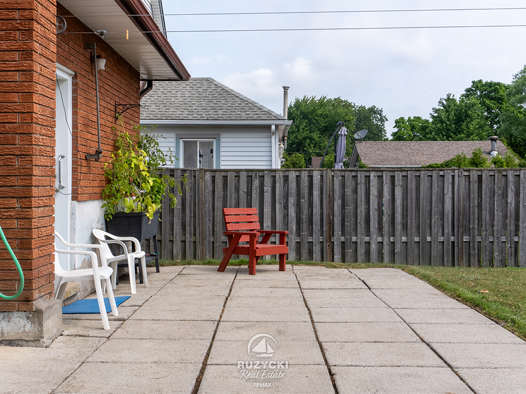 167-wellington-st-port-colborne_01 Back yard patio with red chair