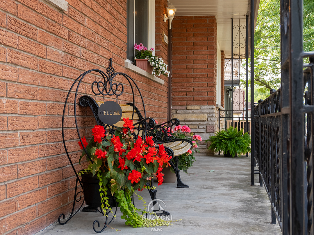 167-wellington-st-port-colborne_30 Front porch with chairs and red cushion at brick bungalow for sale on Wellington Street in Port Colborne