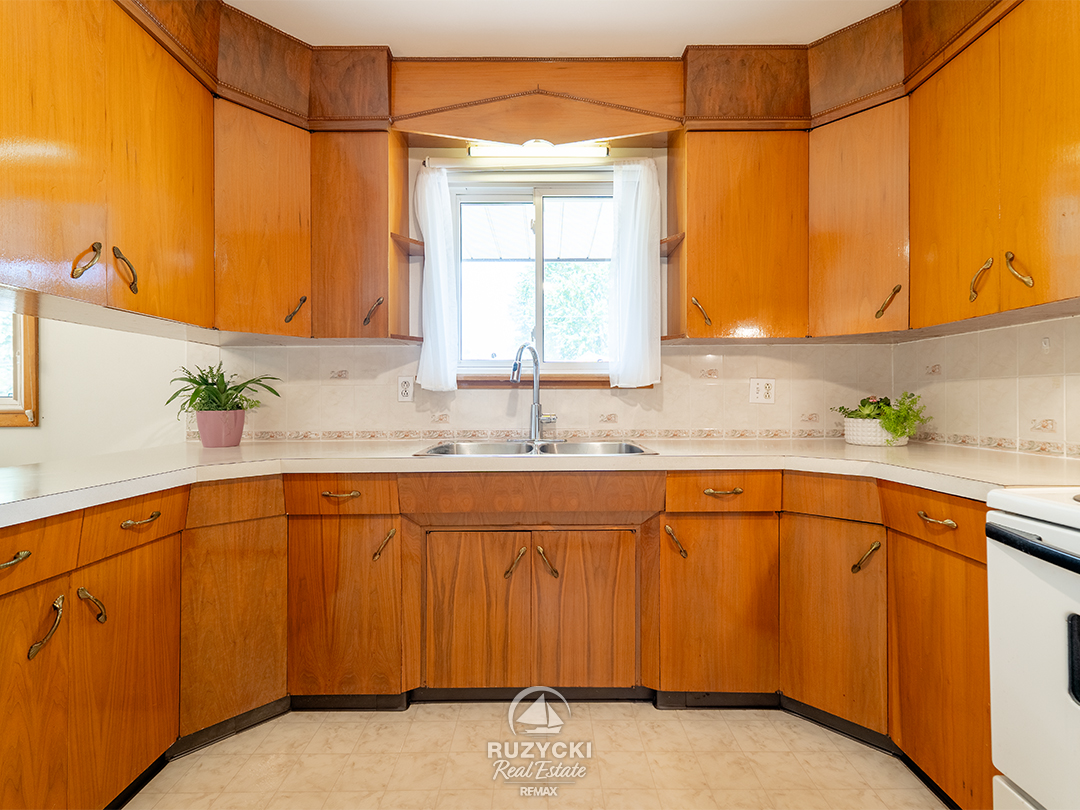 167-wellington-st-port-colborne_37 U shaped kitchen of wood cabinets with window over the sink