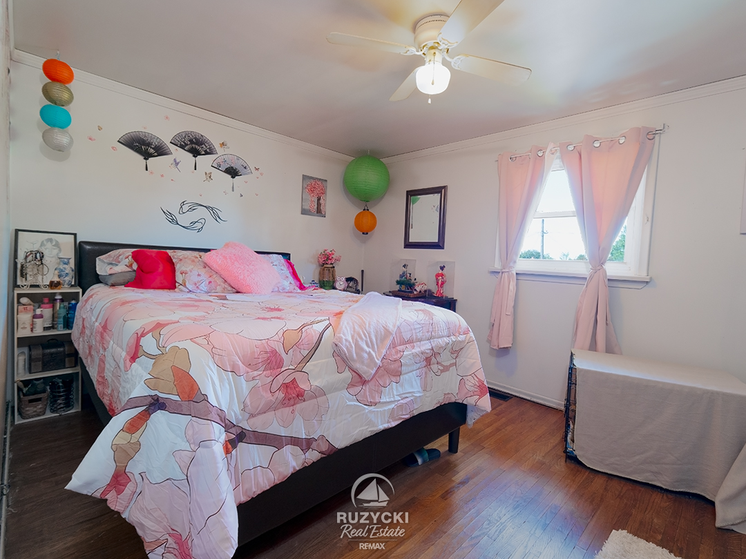 137-wellington-street-port-colborne_20 bedroom with double bed with pink bedspread & curtains