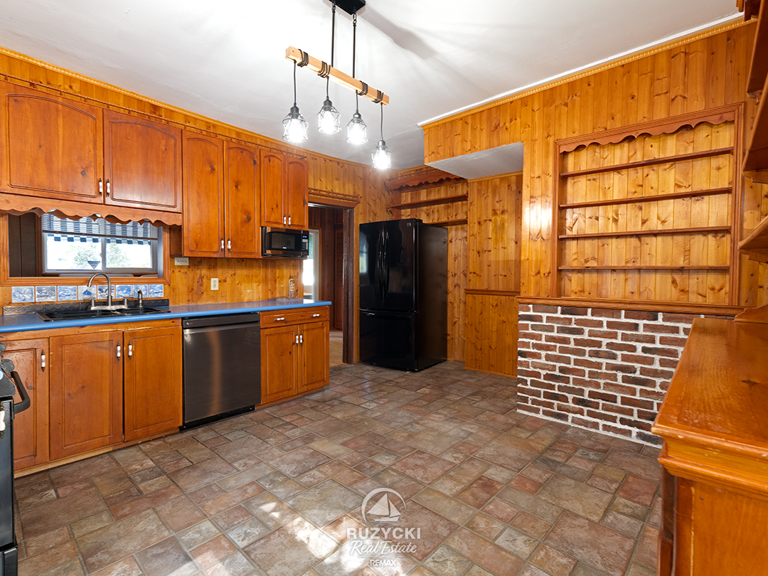 632-king-street-port-colborne_49 wood panelled kitchen with rustic tile floor